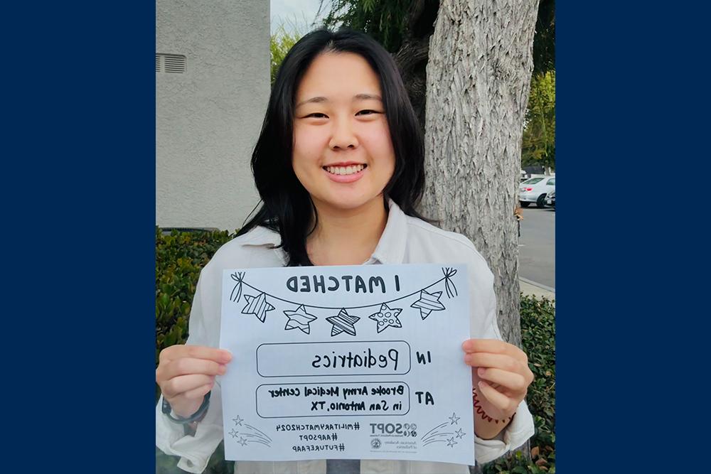 An image of Nikita Lee holding a sign showing where she matched