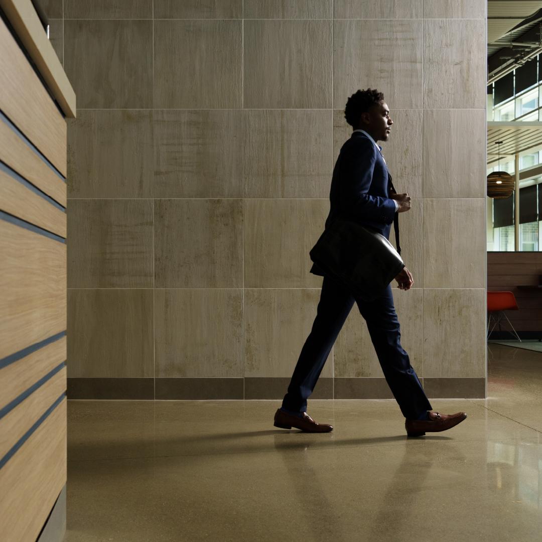 A man in a business suit walking down a hallway